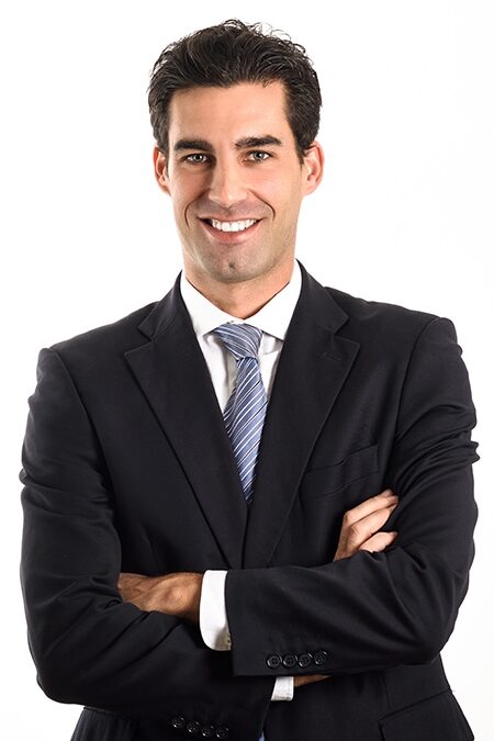 Businessman wearing blue suit and tie on white background.